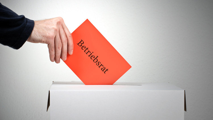 Betriebsratwahl: Der rote Umschlag wandert in die Wahlurne.