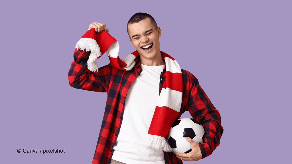 Ein Mann hat einen rot-weiß-gestreiften Schal um den Hals, dieser soll einen Fan-Schal darstellen. Unter dem Arm hat er einen Fußball.