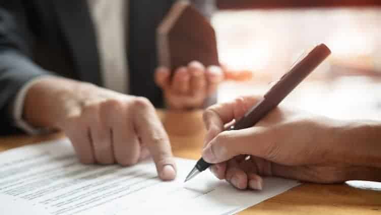 Person zeigt auf Papier und andere Person hält Stift in der Hand
