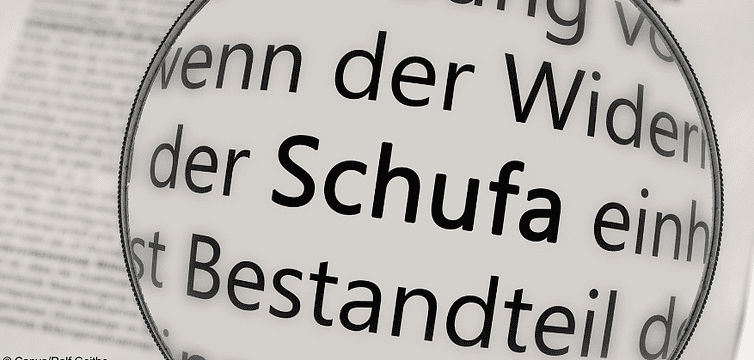 Eine Lupe hat das Wort "Schufa" im Fokus. Denn wir gucken beim Schufa-Score genau hin.