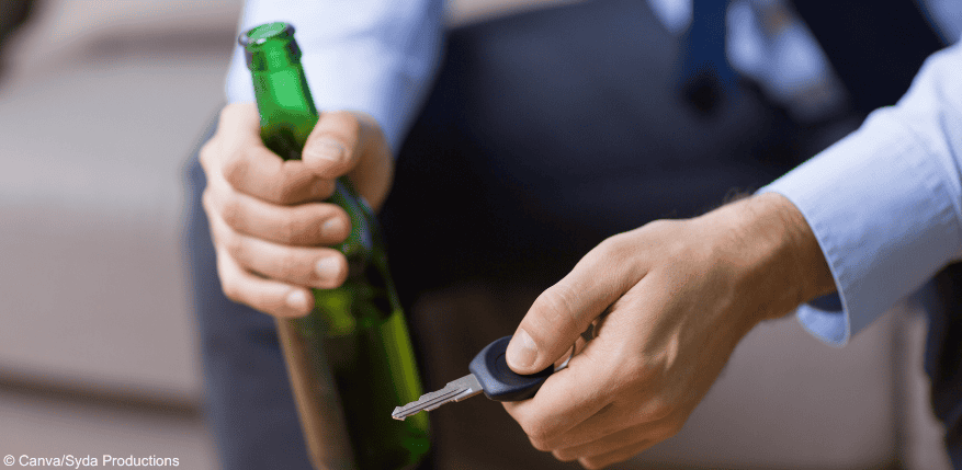 Person mit Alkohol und Autoschlüssel. Gibt es Schmerzensgeld, falls es zu einem Unfall kommt?