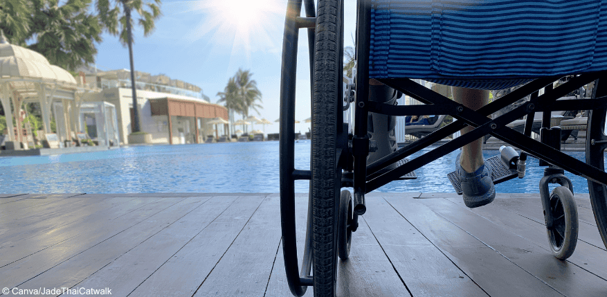 Person im Rollstuhl im Urlaub am Pool. Wann zahlt die EIngliederungshilfe den Urlaub?