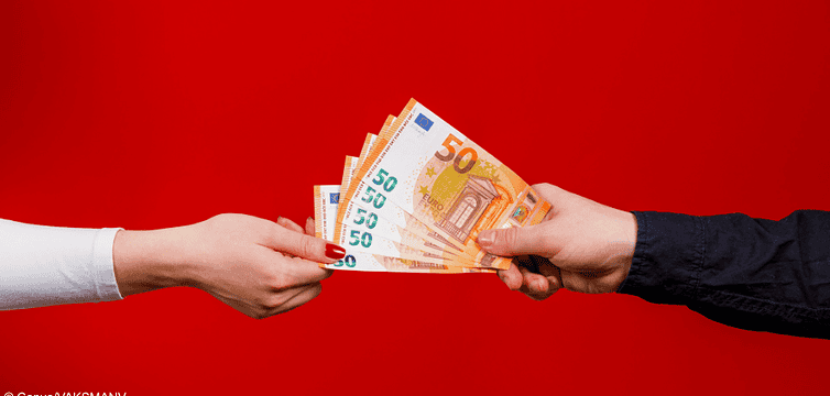 Eine Hand reicht einer anderen mehrere Euroscheine. Kann der Pflichtteil untersagt werden?