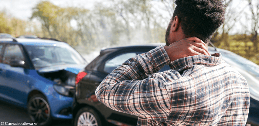 Person steht vor zwei zusammengestoßenen Autos: Gibt es Schadensersatz?