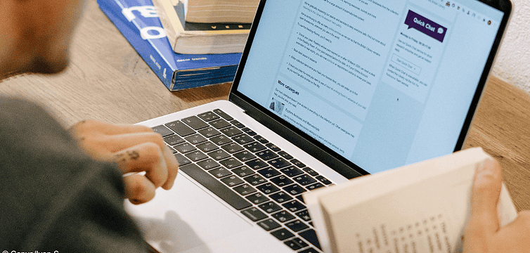 Person am Laptop nutzt KI für Hausarbeit. Das kann zur Exmatrikulation führen.